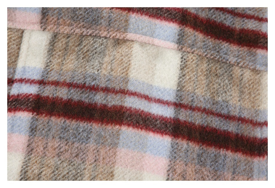 Close-up of fuzzy plaid fabric in beige, gray, pale pink, blue, and red.
