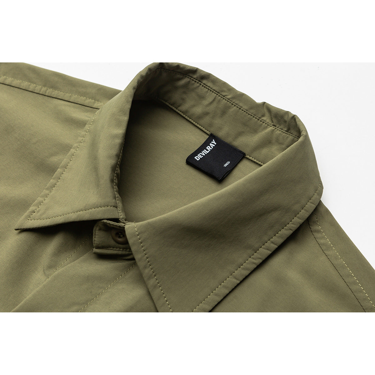 Close-up of an olive-green shirt collar, stitching, button, and black DEVILRAY neck label.