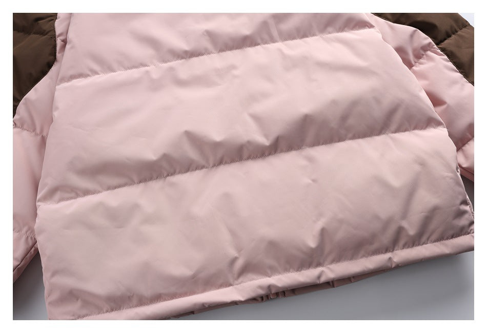 Close-up of the dusty pink quilted jacket body with dark brown panels at the upper edges.
