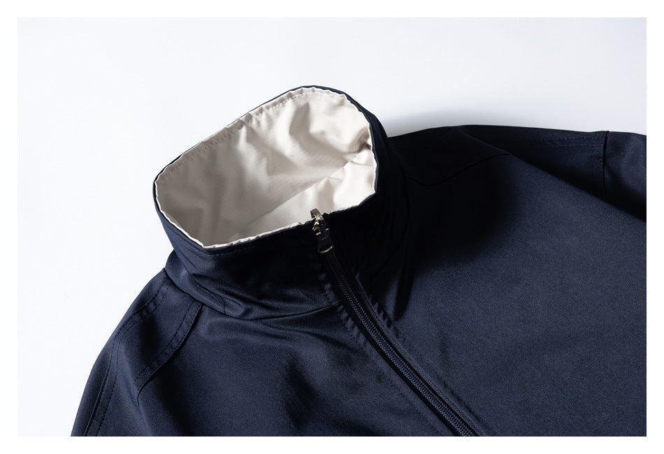 Close-up of a dark navy jacket's light gray-lined stand collar and front zipper.