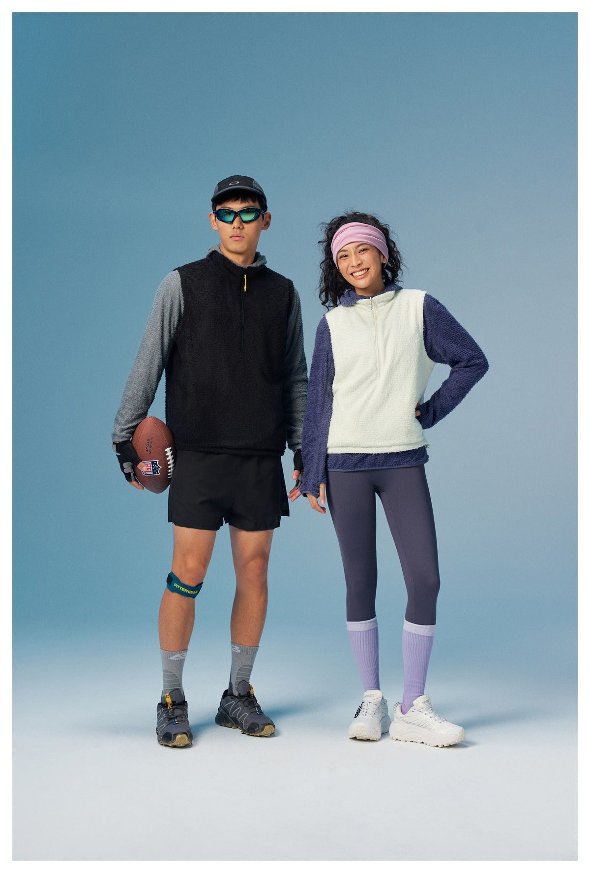 Two models wear a black sleeveless pullover over gray sleeves and a cream vest over purple sleeves.