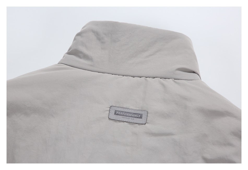 Close-up of a light gray garment collar and a small sewn patch reading “PERFORMANCE” and “KOTMARK 1608.”