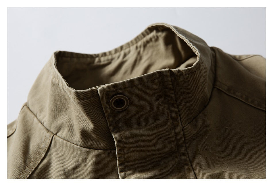 Close-up of an olive-khaki jacket's raised stand collar and buttoned front placket.