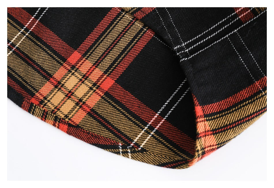 Close-up of the black, red and tan plaid shirt hem and stitched seam.