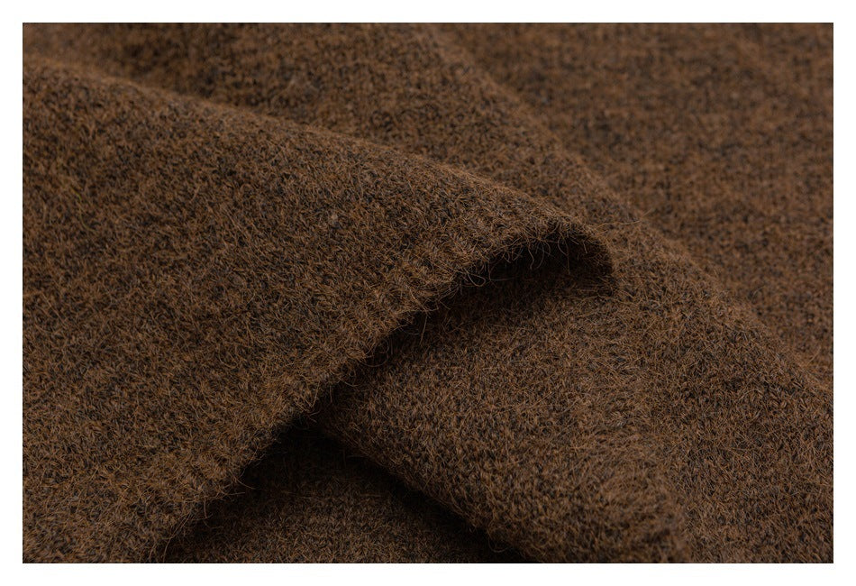 Close-up of brown fuzzy knit fabric draped in overlapping folds.