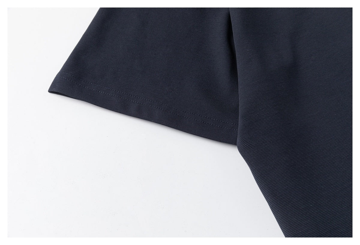 Close-up of the navy polo's short sleeve and stitched sleeve hem.