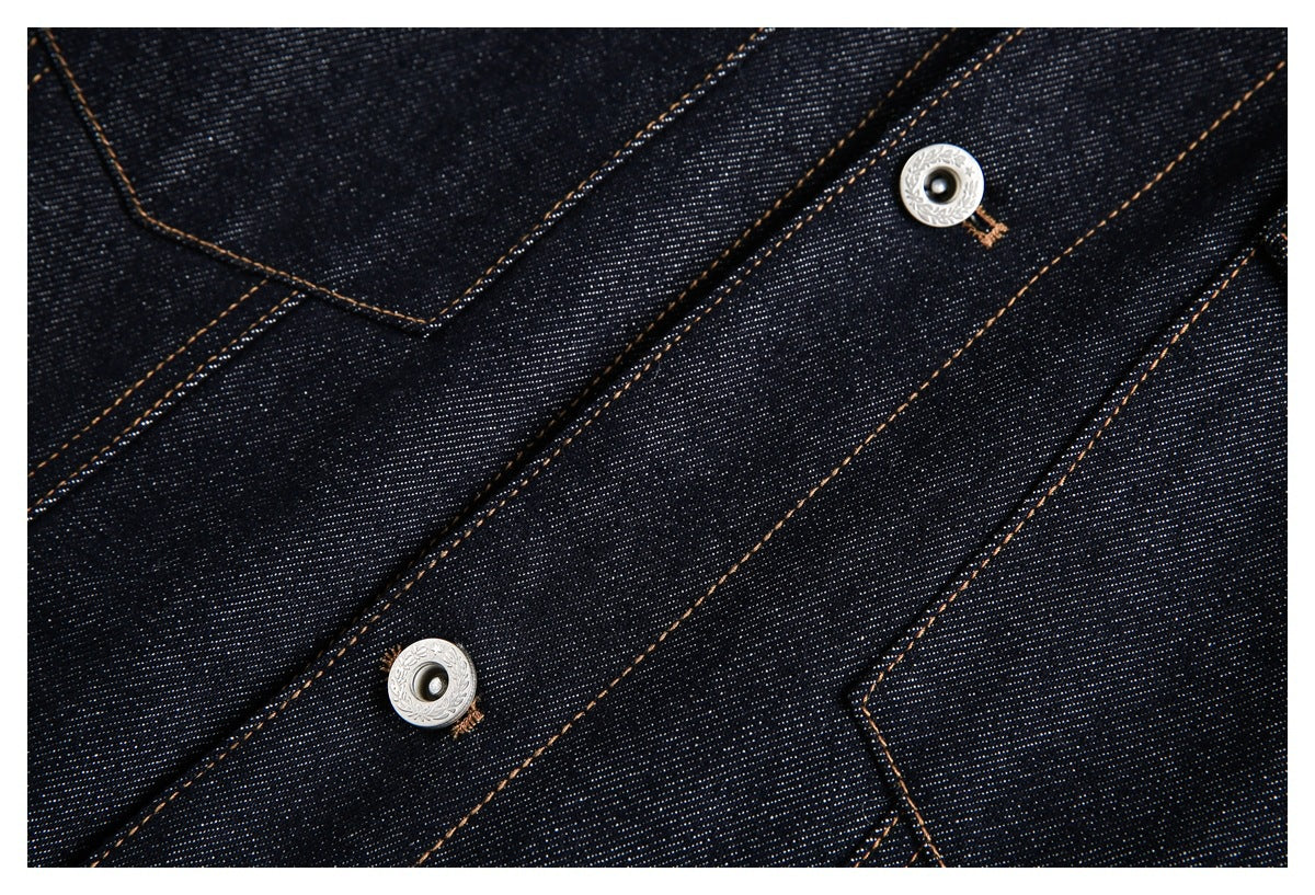Close-up of dark indigo denim seams and decorative silver snap fasteners.