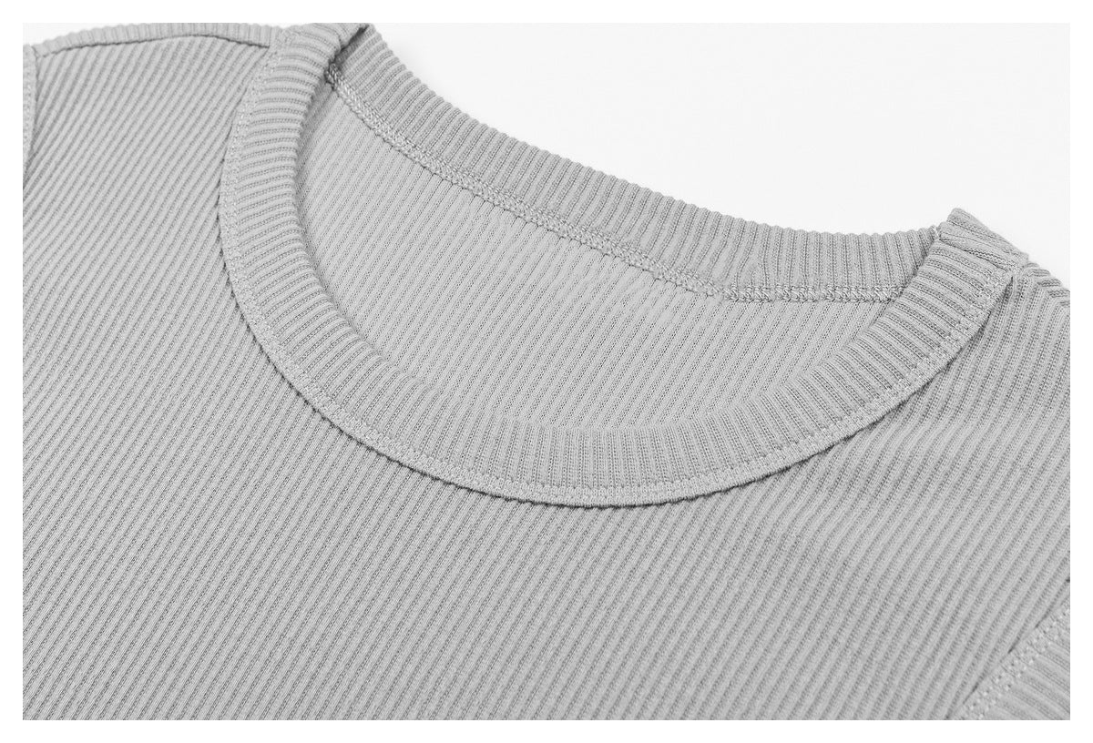 Close-up of a light gray ribbed top's crew neckline and stitching.