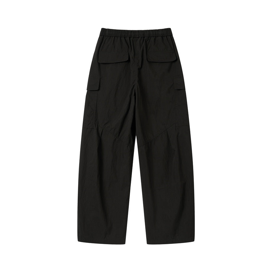 Back view of black wide-leg cargo pants with an elastic waistband, rear flap pockets, and side pockets.