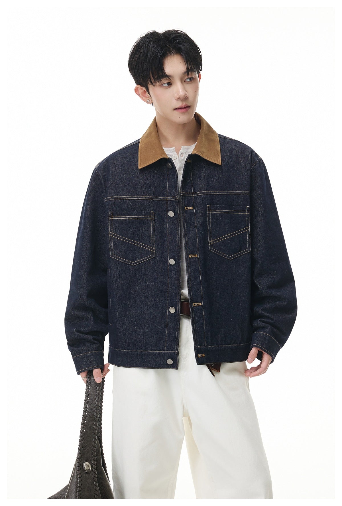 Model wearing an indigo denim jacket with a tan collar, button front and two contrast-stitched chest pockets.