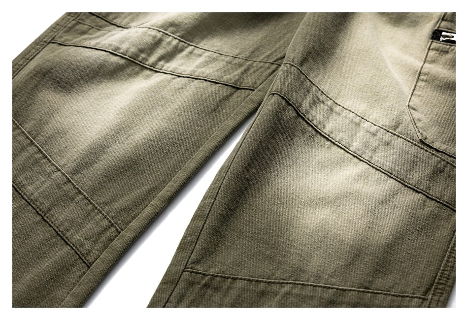 Close-up of olive trouser legs showing panel seams and contrast in the fabric finish.
