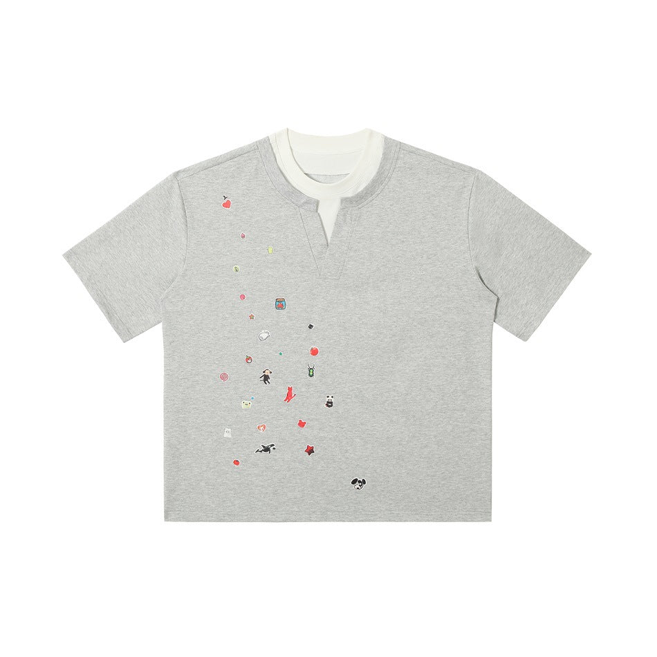 Front view of a light gray short-sleeve T-shirt with a white layered V-notch collar and small colorful chest motifs.