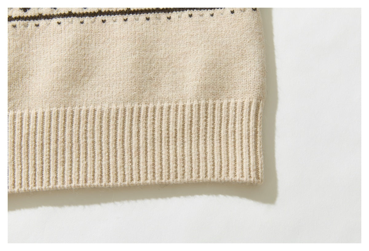 Close-up of the cream cardigan's wide ribbed lower hem and the edge of its dark patterned band.