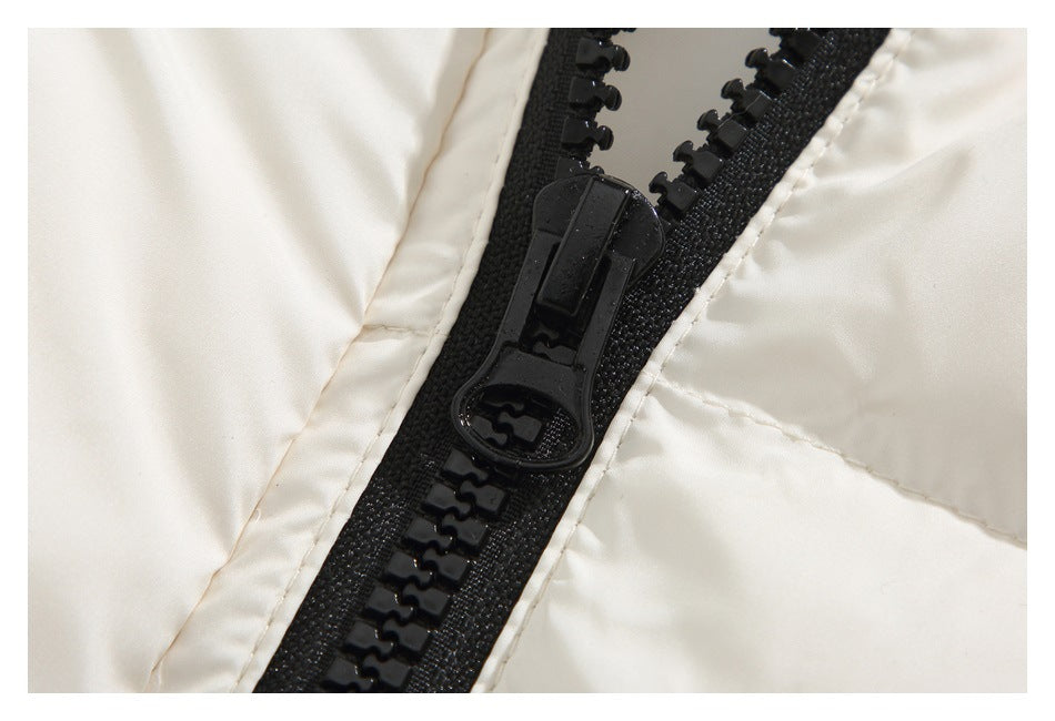 Close-up of a chunky black zipper and pull on cream jacket fabric.
