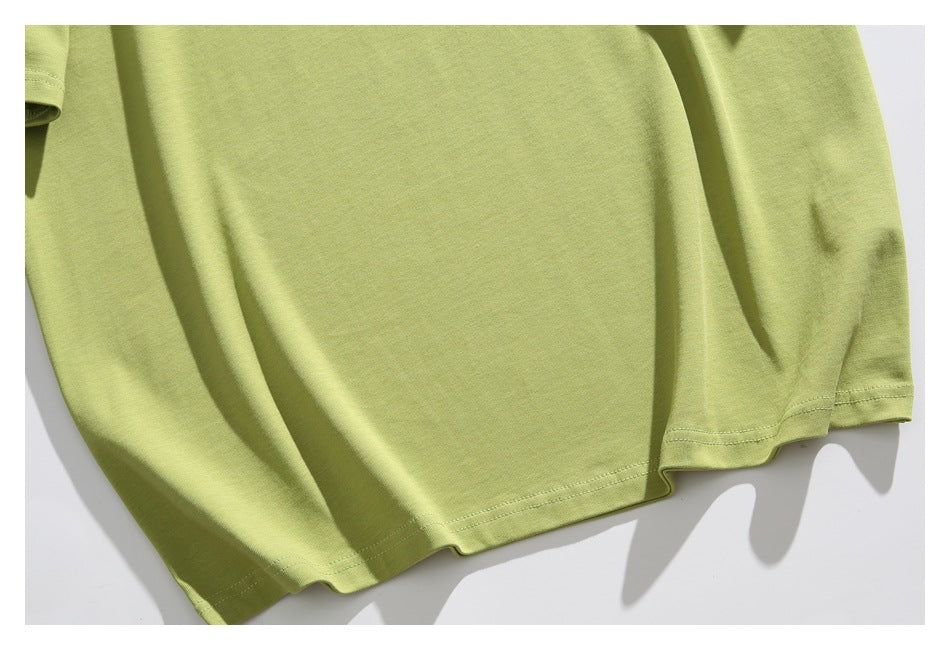 Close-up of the light olive-green T-shirt body and double-stitched bottom hem.