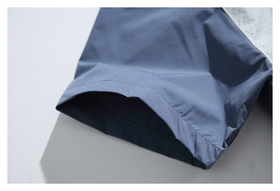 Close-up of the slate-blue jacket sleeve opening and curved stitched edge.