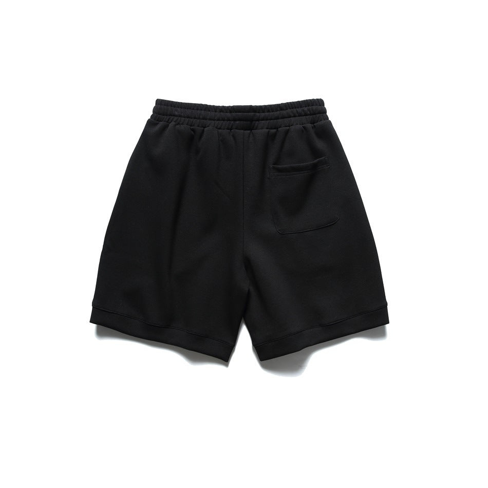 Black shorts back view with elastic waistband and one patch pocket on the right, flat lay