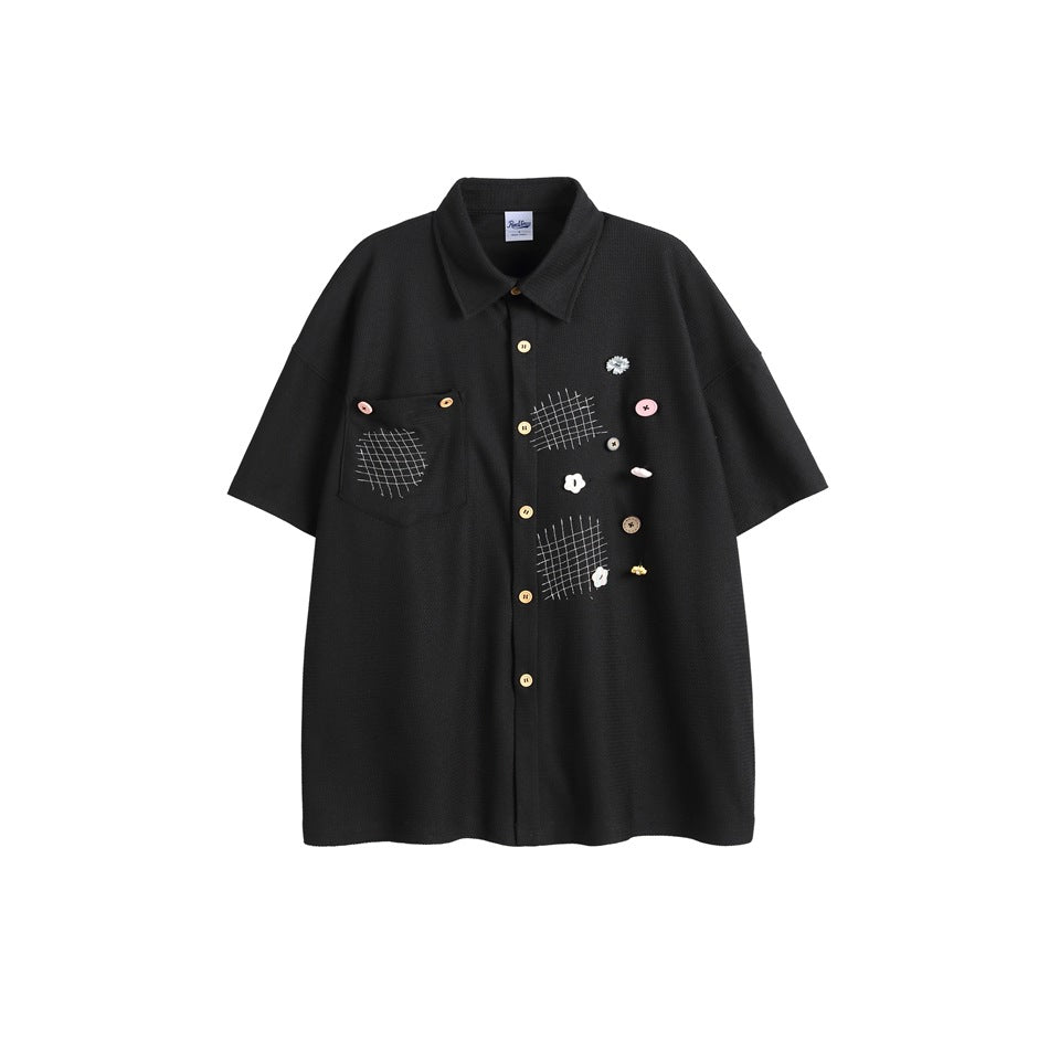Black short-sleeve button-up shirt with chest pocket, grid stitching and decorative buttons, flat front view