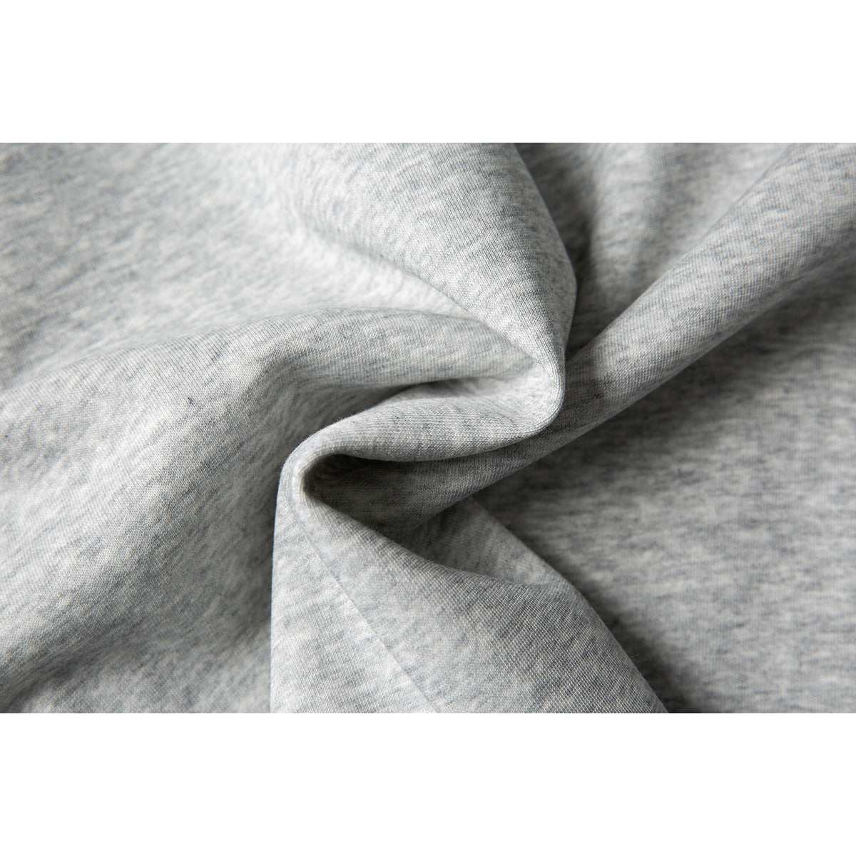 Extreme close-up of the light gray, heathered shirt fabric and its knit texture.