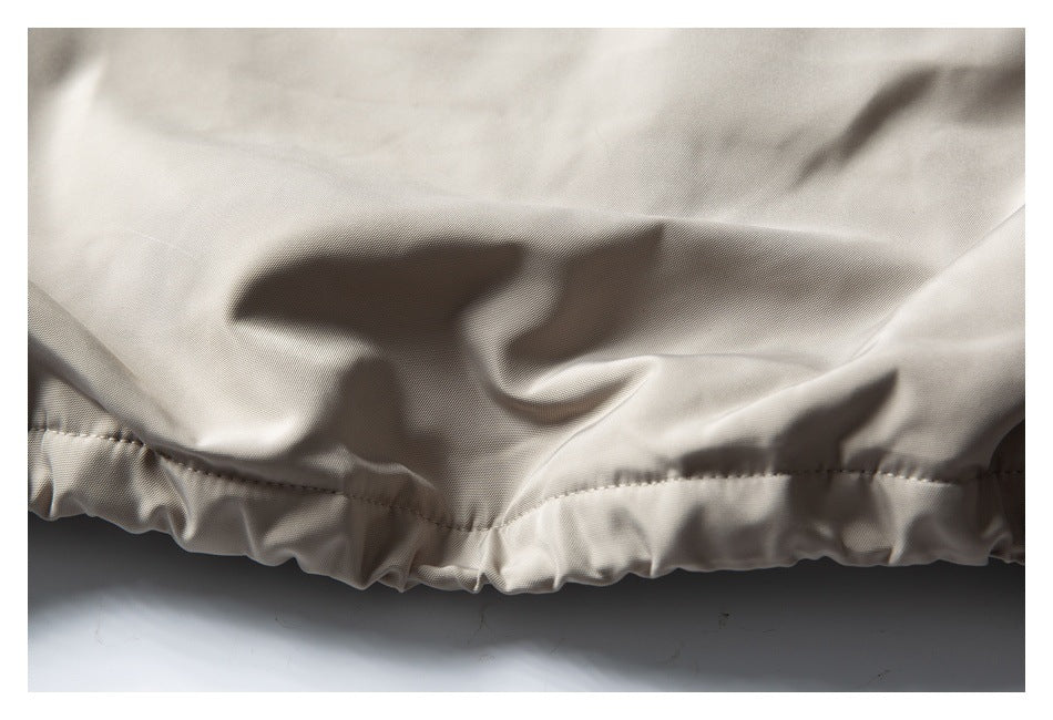 Close-up of a gathered elastic hem on light beige fabric.