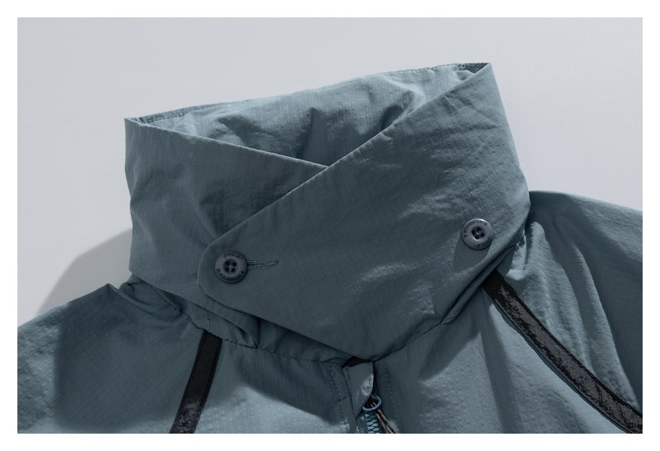 Close-up of a blue-gray high collar with two buttons, black trim and a visible zipper.