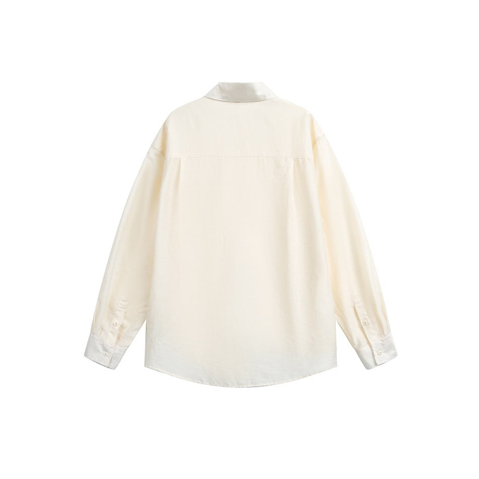 Back view of an off-white long-sleeve button-up shirt with a back yoke and button cuffs, shown flat.