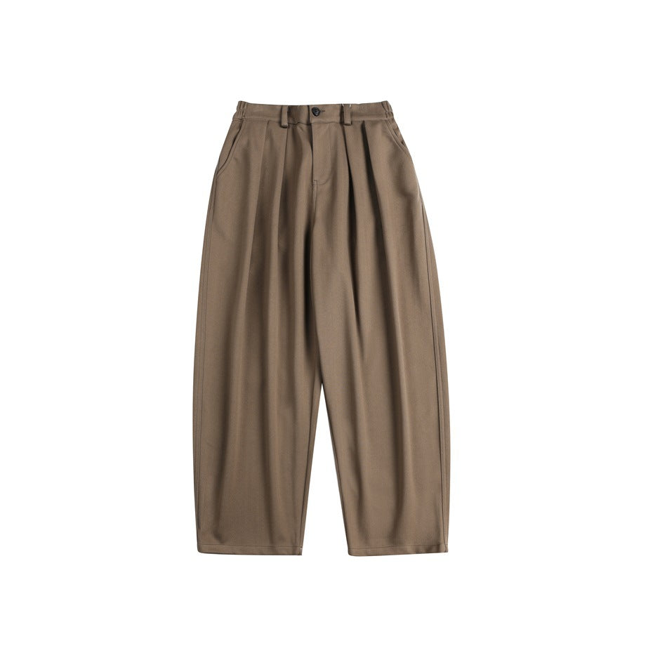 Brown wide-leg pleated trousers laid flat, front view with button, belt loops and side pockets