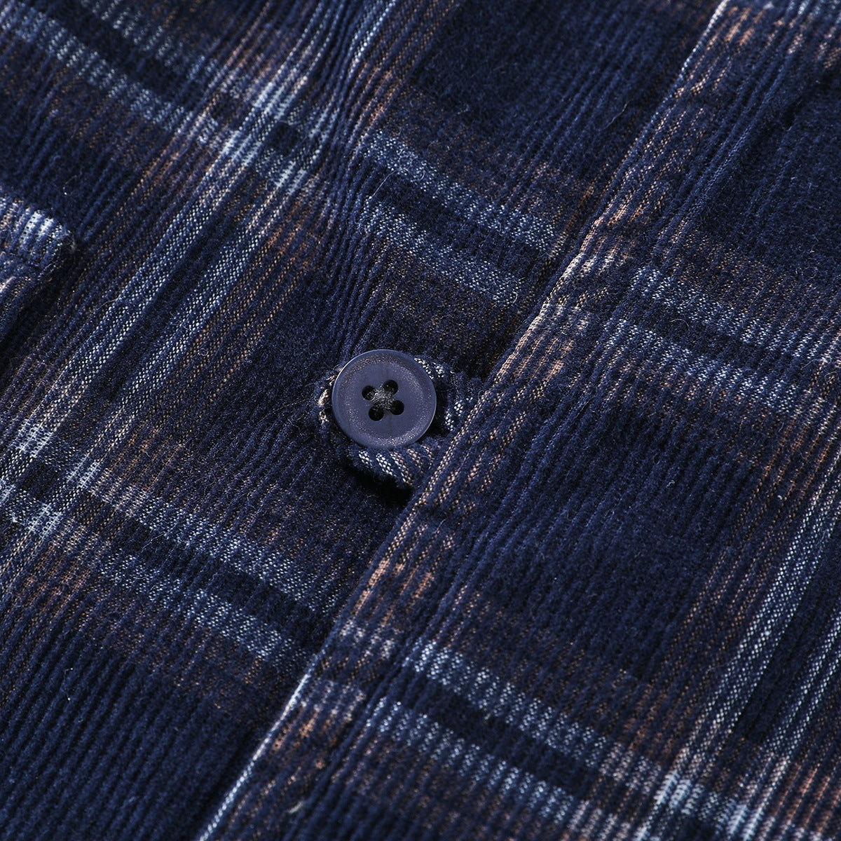 Close-up of a dark button on navy plaid fabric.