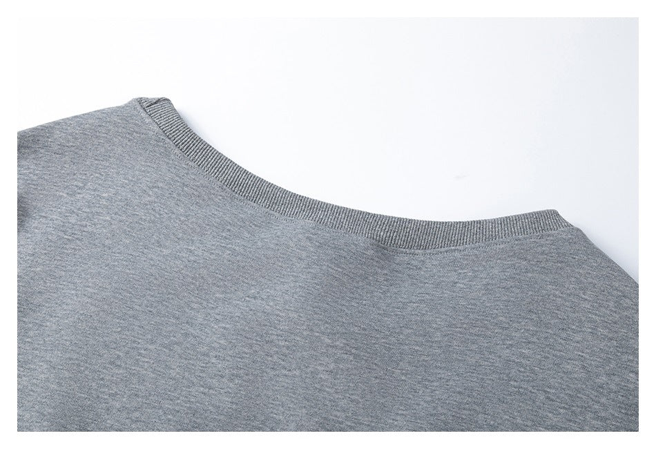 Close-up of the ribbed crew neckline on a gray heather garment.
