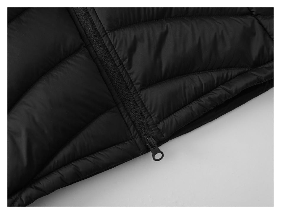Close-up of the black vest's lower front zipper, pull, and quilted hem.