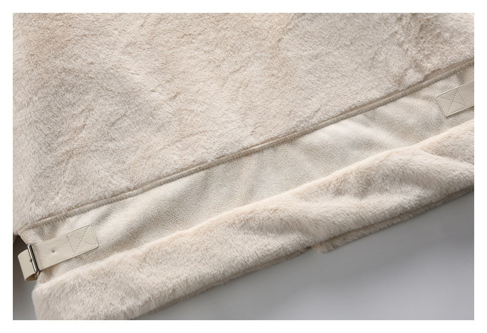 Close-up of the cream coat's lower hem, showing a smooth inset panel and buckle tabs.