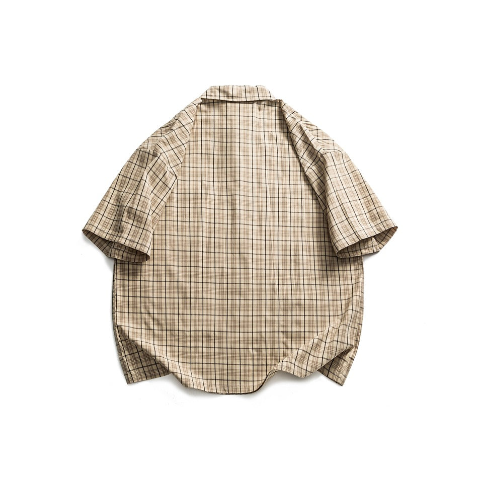 Back view of a beige short-sleeve button-up shirt with a brown and black plaid pattern, laid flat on white.