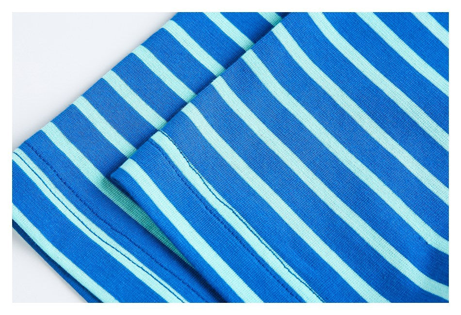 Close-up of blue and pale aqua striped fabric showing a stitched hem.