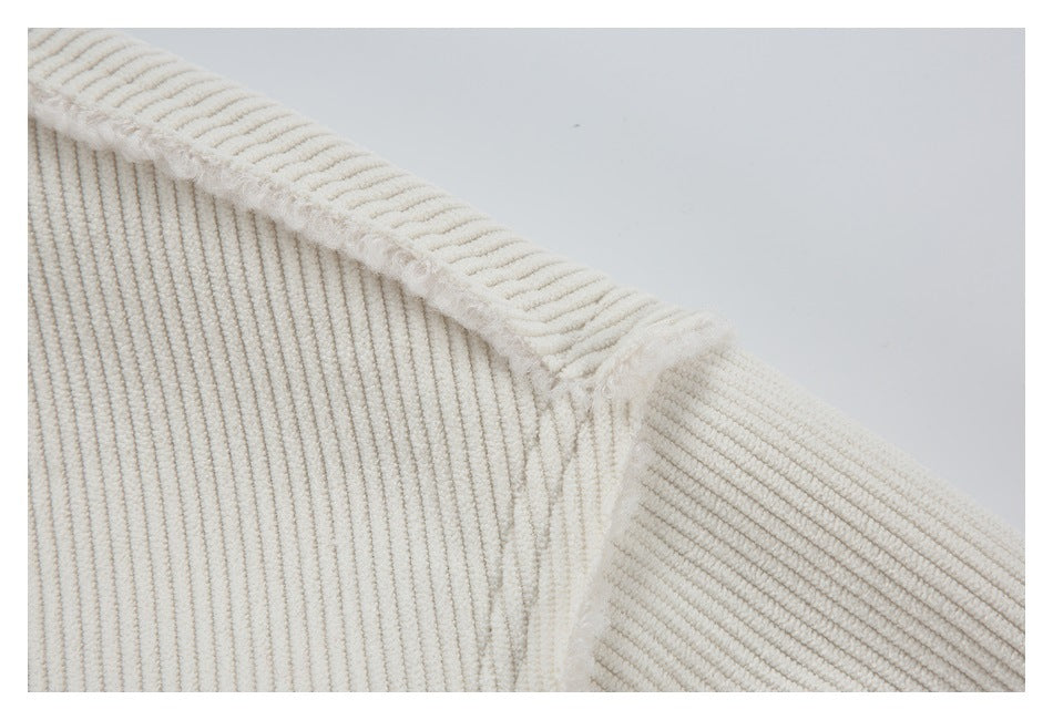 Close-up of an ivory ribbed garment shoulder seam with soft fuzzy trim.
