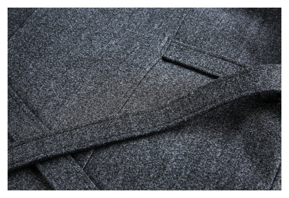 Close-up of a dark charcoal heathered garment with a narrow welt pocket.