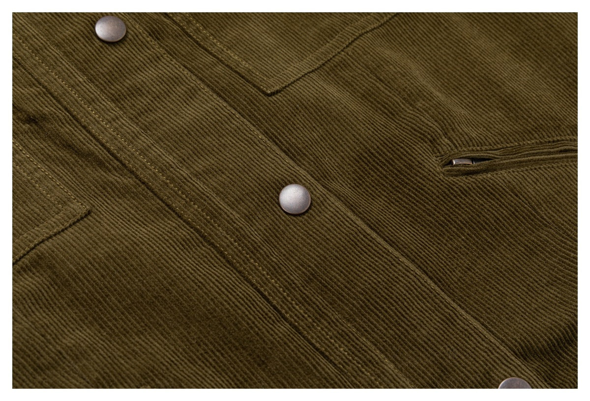 Close-up of olive-brown corduroy fabric showing snap buttons, a stitched panel, and a narrow welt pocket.