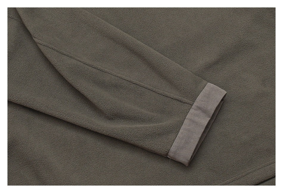 Close-up of dark charcoal garment fabric with a folded sleeve and lighter cuff trim.