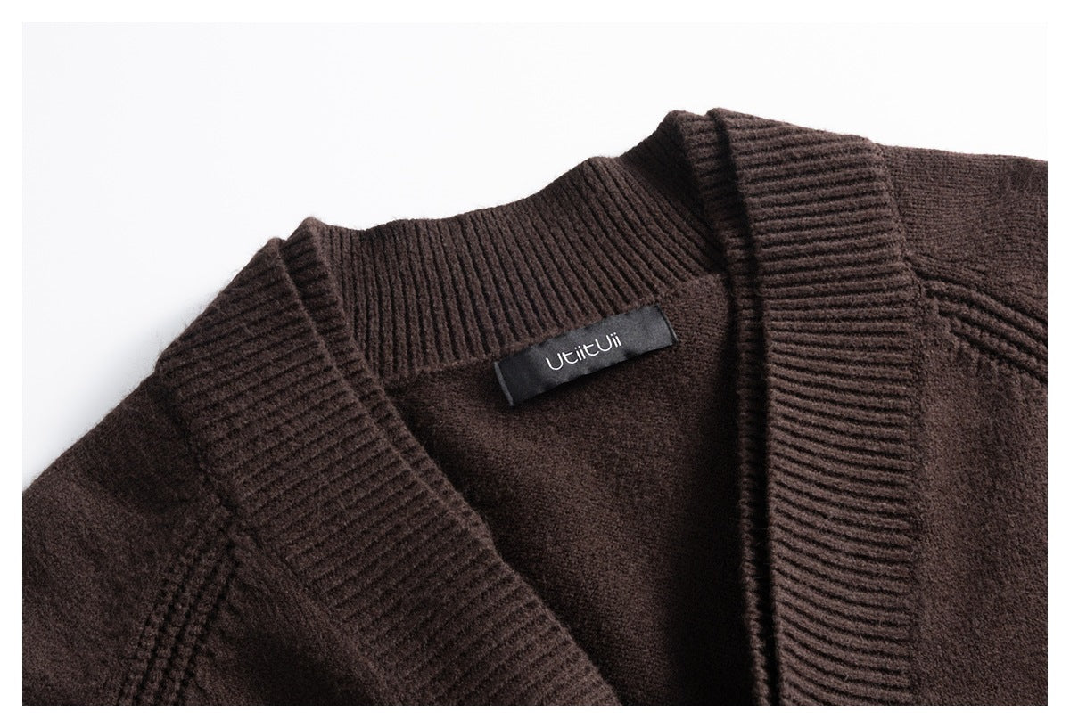 Close-up of a dark brown cardigan’s ribbed shawl collar and inner neck label.