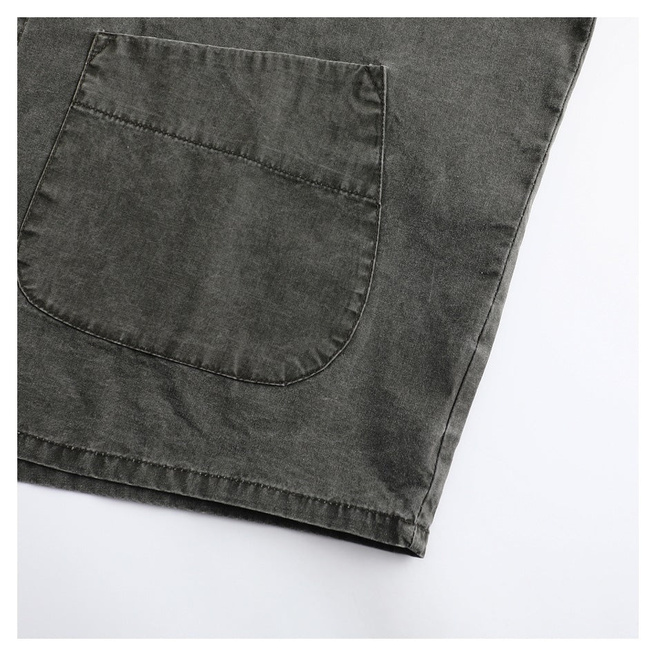 Close-up of a charcoal-gray garment's large patch pocket and stitched hem.
