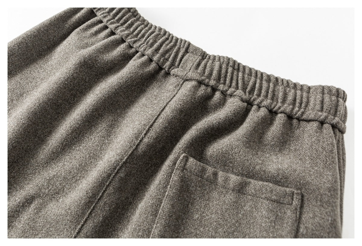 Close-up of the back of gray pants, showing the elastic waistband and a rectangular patch pocket.