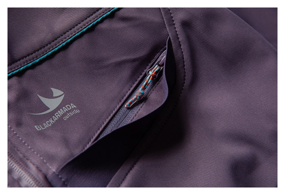 Close-up of a plum jacket pocket with a colorful zipper pull, teal piping, and a Black Armada logo.