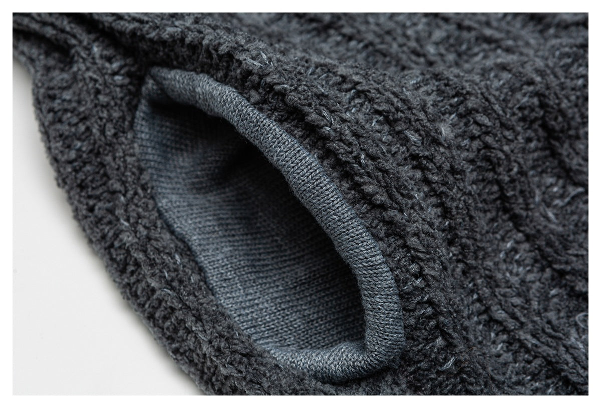 Close-up of a dark charcoal knit garment showing the opening and neatly finished edge of a pocket.