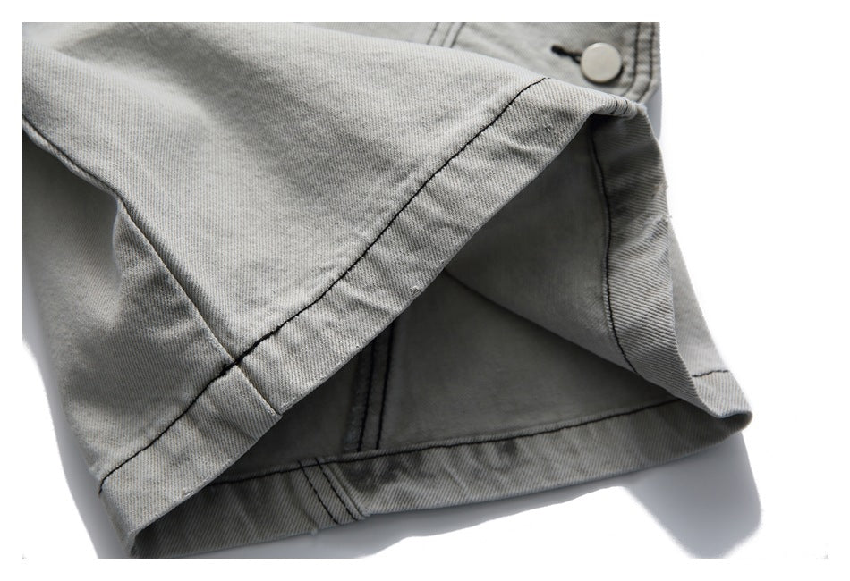 Close-up of the hem and inside opening of a light gray washed denim shorts leg.