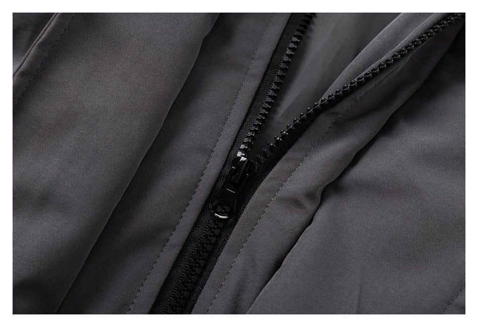 Close-up of a black zipper and placket on a dark gray jacket.