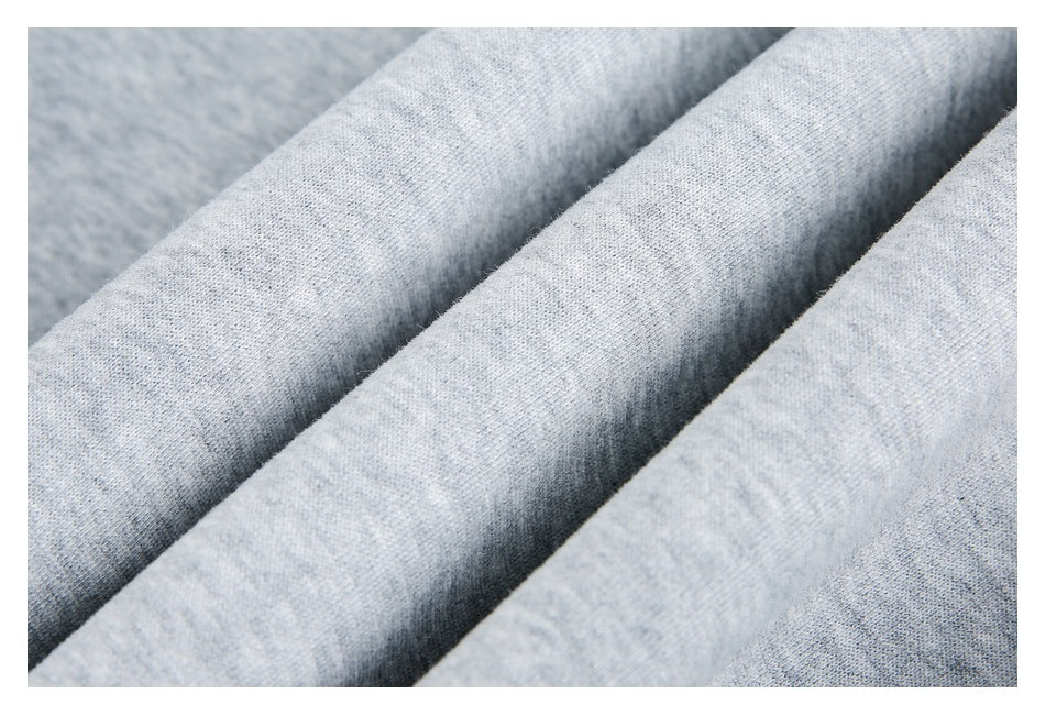 Close-up of light gray heathered fabric folded into soft diagonal ridges.