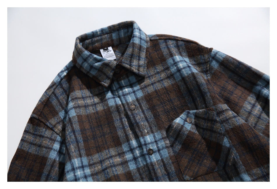 Angled close view of a brown and blue plaid button-up shirt with a pointed collar and chest pocket.