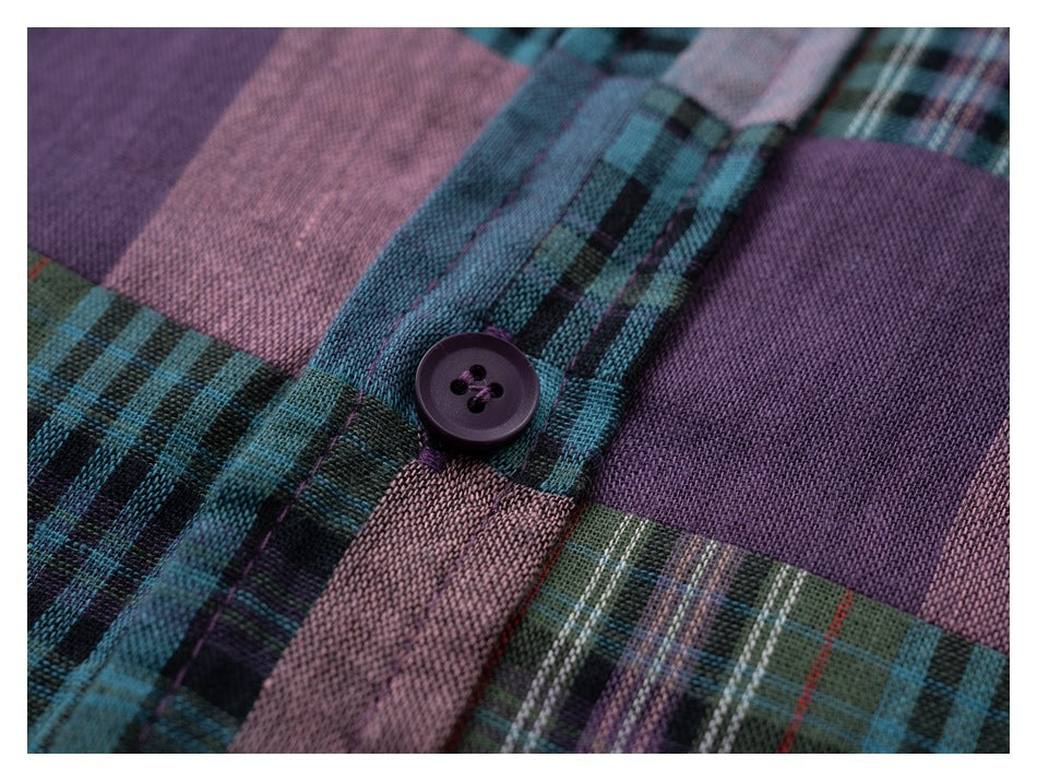 Close-up of a dark purple button on the teal, purple, and pink plaid shirt fabric.