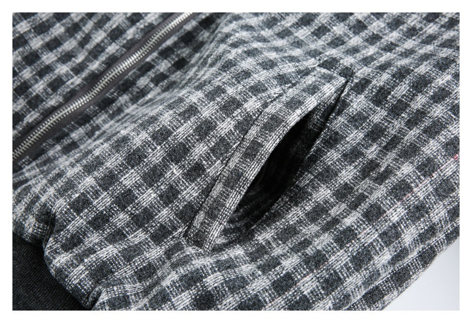 Close-up of a gray plaid jacket's angled pocket opening beside the front zipper.