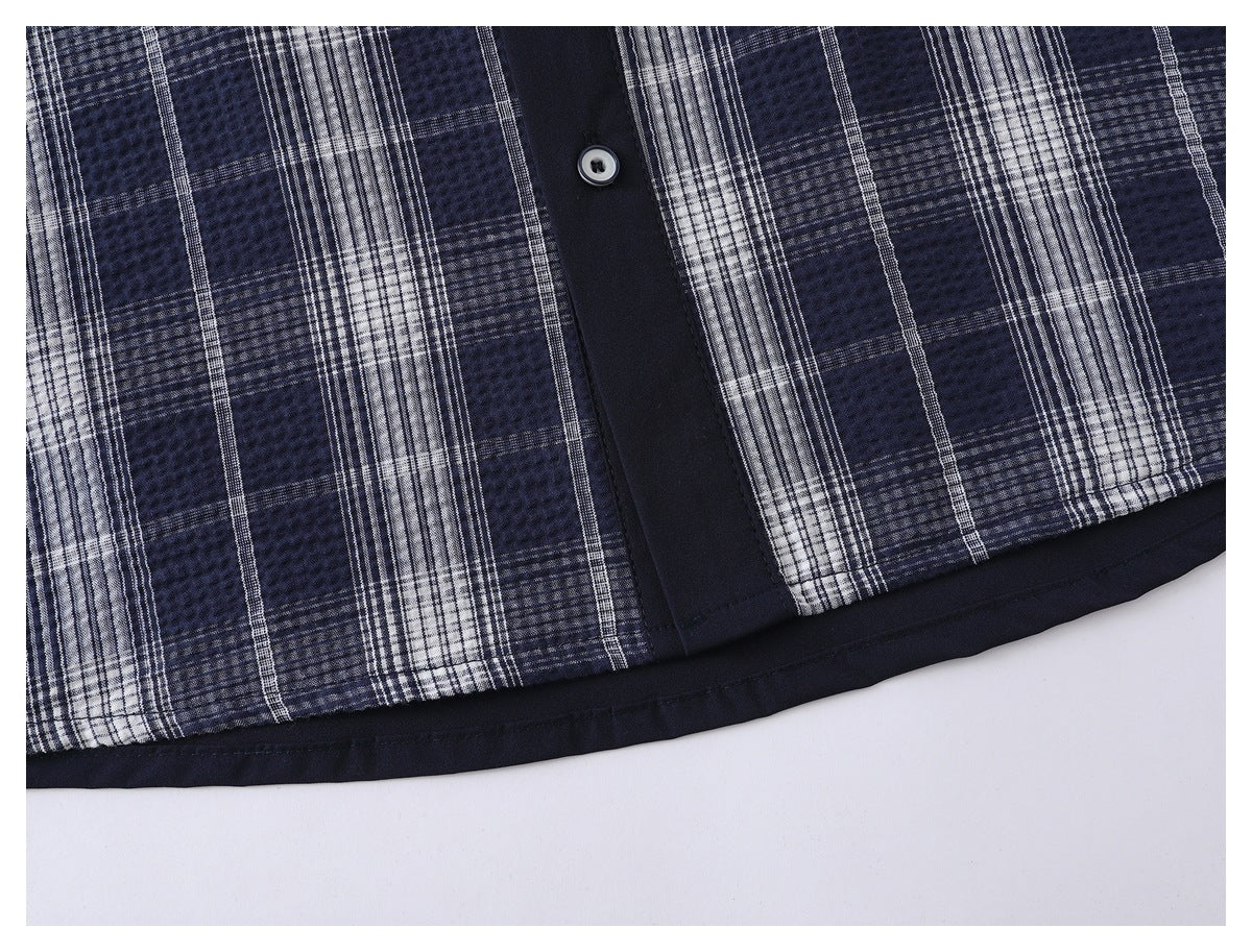 Close-up of the plaid shirt front, navy button placket, and solid navy hem trim.