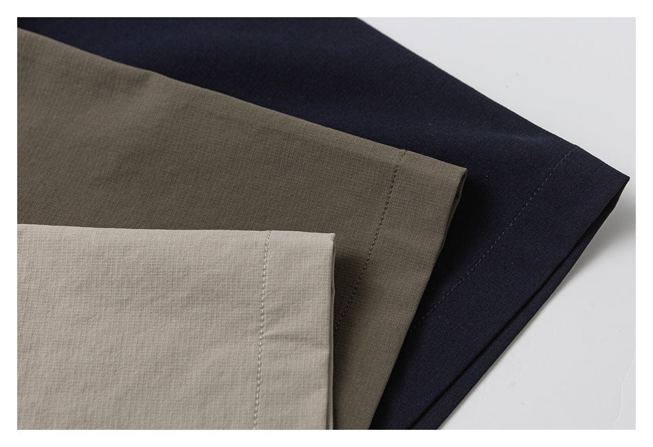 Three overlapping shirt sleeve hems in light taupe, olive, and dark navy.